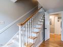 Carpeted staircase with white wood risers and balusters, and wood railing leads to the upper level at 304 Northbrook Dr, Raleigh, NC 27609