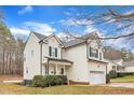 Side view of a well-maintained two-story home with green shutters, attached garage, and manicured landscaping at 309 Amaryllis Way, Wake Forest, NC 27587