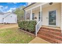 Inviting front porch with brick steps, white railings, and decorative hanging planters at 309 Amaryllis Way, Wake Forest, NC 27587