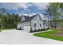 Side view of the home showing a long driveway, attached garage, and well manicured lawn at 3909 Cedar Knolls Dr # 6, Youngsville, NC 27596