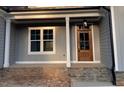 Home exterior featuring a stone porch and a wood front door at 3909 Cedar Knolls Dr # 6, Youngsville, NC 27596