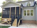 Covered porch with stairs and black railings overlooks the backyard at 3909 Cedar Knolls Dr # 6, Youngsville, NC 27596