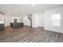 Open-concept living area features wood-look floors, kitchen view and staircase to the second floor at 3920 Willow Gate Way, Raleigh, NC 27604