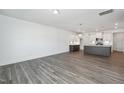 Bright living room features stylish lighting, wood-look floors, and connects seamlessly to the kitchen at 3920 Willow Gate Way, Raleigh, NC 27604