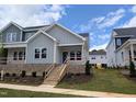 Inviting gray two-story home showcasing a lovely front porch with brick base and newly landscaped front yard at 3928 Willow Gate Way, Raleigh, NC 27604