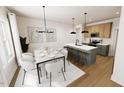 Open-concept kitchen and dining area featuring modern lighting, countertops, and stainless steel appliances at 3928 Willow Gate Way, Raleigh, NC 27604