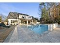 Gorgeous backyard featuring an in-ground pool, stone deck, and covered patio space with fireplace at 4329 Lambeth Dr, Raleigh, NC 27609