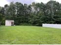 Spacious backyard with a storage shed and fenced perimeter, offering privacy and practicality at 711 Weathervane Way, Rocky Mount, NC 27803