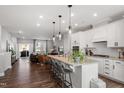 Open concept kitchen features island seating, pendant lights, and a view to the living area at 1014 Falling Rock Pl, Durham, NC 27703