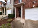 Close-up of a brick townhome entrance with covered porch and well-kept landscaping at 102 Forrymast Trl, Apex, NC 27539