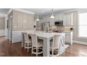 Stylish kitchen with white cabinets, quartz countertops, pendant lighting, and hardwood floors at 1117 Golden Star Way, Wake Forest, NC 27587
