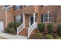 Inviting brick home featuring a classic black front door and white trim, framed by manicured landscaping at 1122 Virginia Water Dr, Rolesville, NC 27571