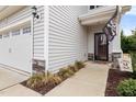 Home's front entry features a decorative front door, sidelight, landscaping, and sideload garage at 176 E Ravano Dr, Clayton, NC 27527