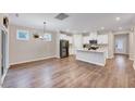 Open-concept design with a bright, modern kitchen featuring white cabinetry, stainless steel appliances, and hardwood flooring throughout at 186 Madden Rose Loop, Garner, NC 27529