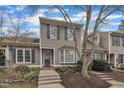 Charming townhouse featuring neutral siding, blue shutters, and a well-manicured front yard at 2 Forest Green Dr, Durham, NC 27705