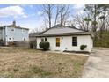 Inviting single-story home displaying a white brick facade, complemented by subtle landscaping and an open front yard at 2305 Fitzgerald Ave, Durham, NC 27707