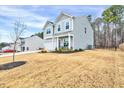 Side view of a gray two-story home showcasing the manicured lawn and fence in the backyard at 240 Forest Meadow Ln, Franklinton, NC 27525