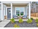 Inviting front porch with seating, decorative plants, and a view of the landscaped front yard at 240 Forest Meadow Ln, Franklinton, NC 27525