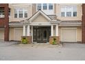 Inviting building entrance featuring double doors, white columns, and two attached garages on either side of the entryway at 2810 Bedford Green Dr # 300, Raleigh, NC 27604