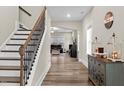 Inviting foyer with wood floors, staircase, decorative table and artwork creating a warm welcome at 2981 Thurman Dairy Loop, Wake Forest, NC 27587