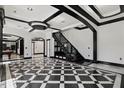Impressive foyer with black and white tiled floors, a glass railed staircase, and modern lighting at 318 W Lillington St, Angier, NC 27501