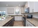 Kitchen featuring granite countertops, stainless steel appliances, and wooden floor at 3429 Ferdilah Ln, Raleigh, NC 27610