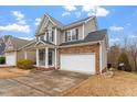 Traditional home with a covered front porch, two-car garage, and brick and gray siding exterior at 4909 Jelynn St, Raleigh, NC 27616