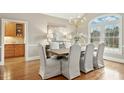 Dining room features hardwood floors, chandelier, large window, and a sideboard at 5204 Winter Holly Ct, Raleigh, NC 27606