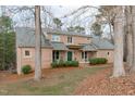 Brick two-story home with a welcoming front porch, landscaped shrubs, and a well-maintained lawn at 5512 Spring Bluffs Ln, Raleigh, NC 27606