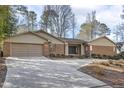 Lovely brick home featuring a well-kept lawn, mature trees, and an expansive concrete driveway at 6065 Merion Cir, Sanford, NC 27332