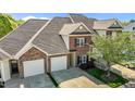 Overhead view of a two-story brick townhouse featuring a two-car garage and manicured lawn at 638 Village Lake Dr, Mebane, NC 27302