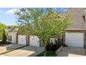 Townhouse featuring a brick facade, two-car garage, landscaping, and a mature tree at 638 Village Lake Dr, Mebane, NC 27302