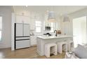 Bright, modern kitchen with white cabinets, stainless steel appliances, a center island with seating, and stylish pendant lighting at 1005 Whistler St, Durham, NC 27713
