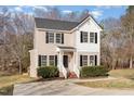 Inviting two-story home featuring a classic design with a cozy front porch and neatly manicured bushes at 105 Caribbean Ct, Knightdale, NC 27545