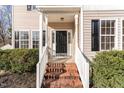 Close-up of a front porch featuring brick steps, white railings, and a dark-colored front door at 105 Caribbean Ct, Knightdale, NC 27545
