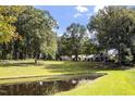 Picturesque pond reflecting the surrounding trees and sky, set against a backdrop of lush greenery at 105 D Hart Rd, Siler City, NC 27344