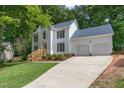 Well-maintained two-story home with a two-car garage and a long driveway, surrounded by lush greenery at 112 Ridgepath Way, Cary, NC 27511
