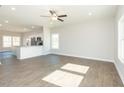 Open living space with hardwood floors connecting to a modern kitchen with a bar and stainless steel appliances at 132 Ambergate Ct, Rocky Mount, NC 27804
