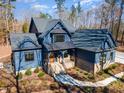 Aerial view of a home showing its well-manicured yard, stone accents, and sprawling roof at 148 Evington Dr, Pittsboro, NC 27312