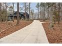 Long driveway leading to a luxury two-story home nestled among mature trees at 148 Evington Dr, Pittsboro, NC 27312