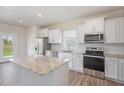 Bright kitchen with stainless steel appliances, granite countertops, and stylish white cabinetry at 1509 Rhodes Pond St, Wendell, NC 27591