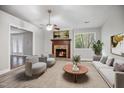 Comfortable living room with a fireplace, large window, and stylish furniture at 1512 Maybrook Dr, Raleigh, NC 27610