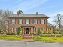 Charming two-story brick home featuring beautiful landscaping, shutters, and a well-maintained front yard at 201 W Park Dr, Raleigh, NC 27605