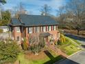 Beautiful brick home with a well-kept lawn, mature trees, and charming front walkway at 201 W Park Dr, Raleigh, NC 27605