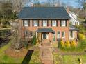 Classic brick home featuring a well-manicured lawn and walkway leading to the front door at 201 W Park Dr, Raleigh, NC 27605