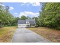 Two-story home with three-car garage, manicured lawn, mature trees, and large driveway with side yard at 270 S Ridge Dr, Garner, NC 27529
