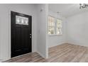 Bright entryway featuring hardwood floors, a black front door, and natural light at 3 Duxford Ct, Durham, NC 27703