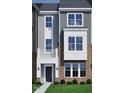 The townhome boasts a brick and siding facade, complemented by a balcony and decorative window features at 319 Chesapeake Commons St # 103, Garner, NC 27529