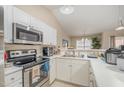 Bright kitchen features white cabinetry, stainless steel appliances, and ample counter space at 3322 Wellington Ridge Loop, Cary, NC 27518