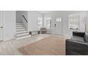 Bright living room with white walls, light wood floors, and a staircase, offering a fresh, modern feel at 405 N Hyde Park Ave, Durham, NC 27703